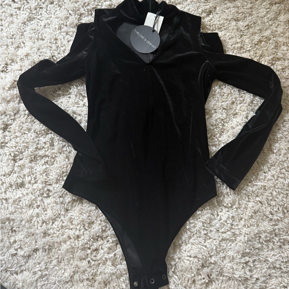 Black velvet bodysuit with zipper peekaboo collar and ruffle details. NWT